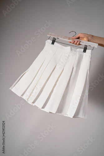 Mockup white pleated skirt, teenager girl school uniform on neutral gray background. Mock up