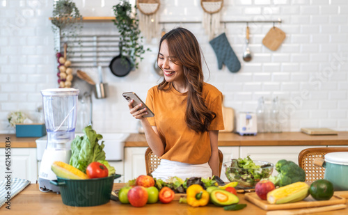 Portrait of beauty body slim healthy asian woman having fun cooking and preparing cooking vegan food healthy eat with fresh vegetable salad on counter in kitchen at home.Diet.Fitness  healthy food