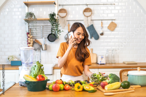 Portrait of beauty body slim healthy asian woman having fun cooking and preparing cooking vegan food healthy eat with fresh vegetable salad on counter in kitchen at home.Diet.Fitness, healthy food
