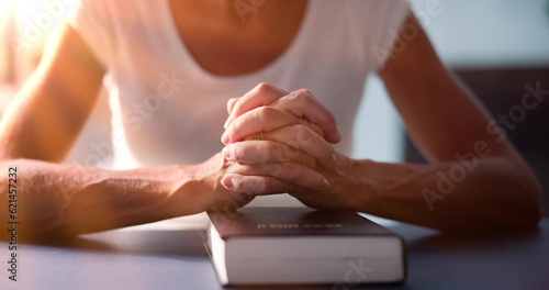 Sunlight Falling On Woman's Hand Over Holy Bible