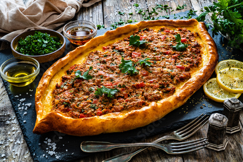 Turkish pide - Turkish flatbread pizza with minced meat on wooden background
 photo