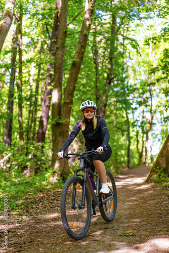 Woman riding bicycle in forest 