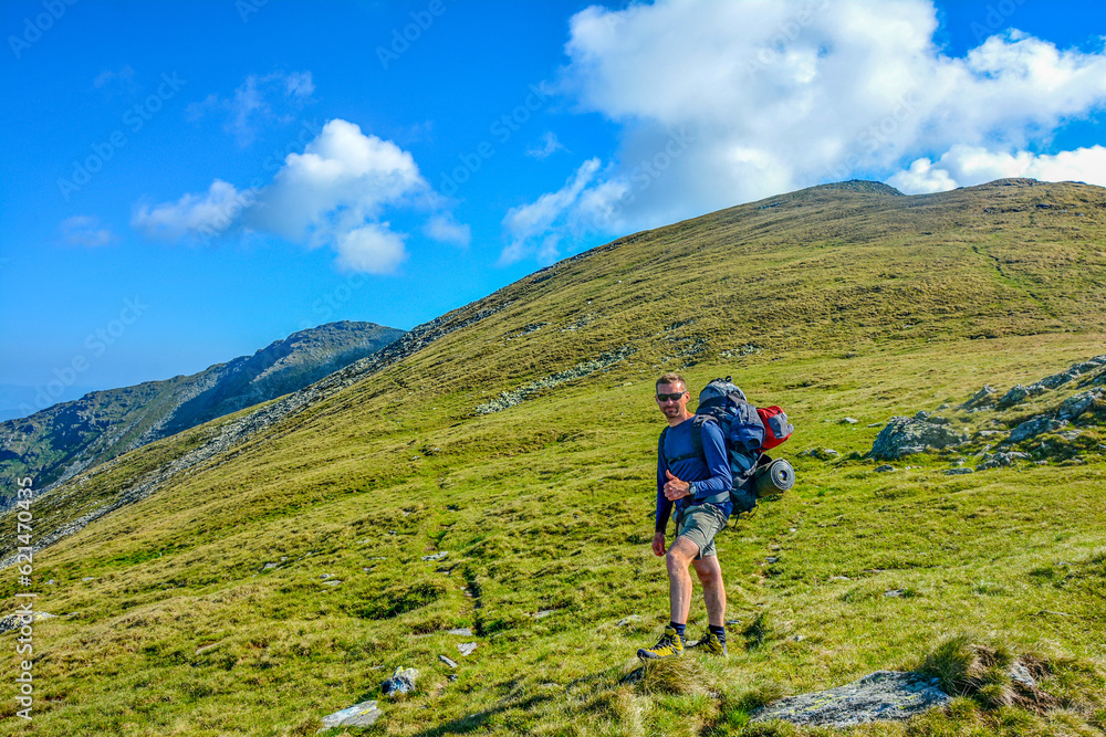 Fototapeta premium Young man trekking beautiful mountain