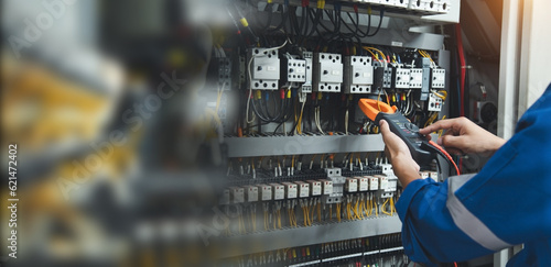 Electrician measurements with multimeter testing current electric in control panel, safety concept . photo