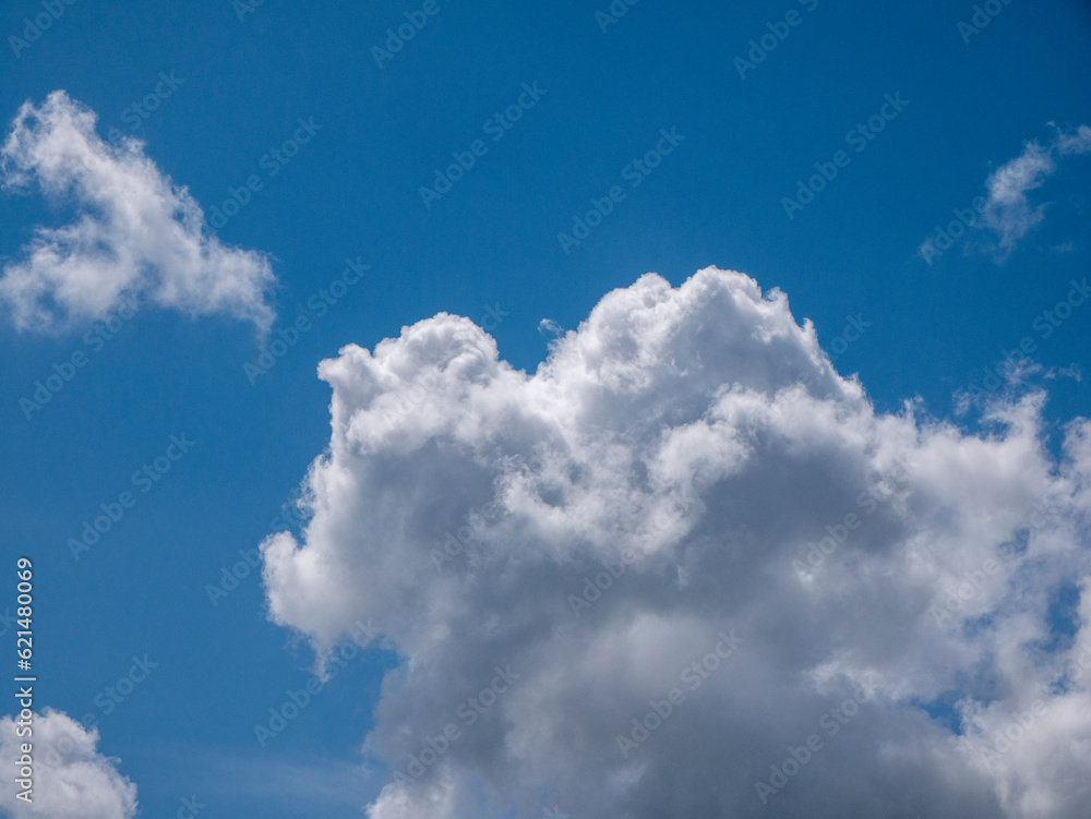 Obraz premium White fluffy clouds in the deep blue sky background