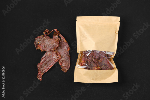 Fotografía Overhead view of dried beef jerky meat in paper package