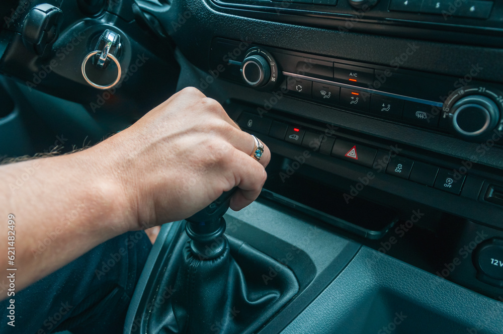 a man holds his hand on the gearshift lever in the car there is a place for an inscription a man holds his hand on the gearshift lever in the car there is a place for an inscription