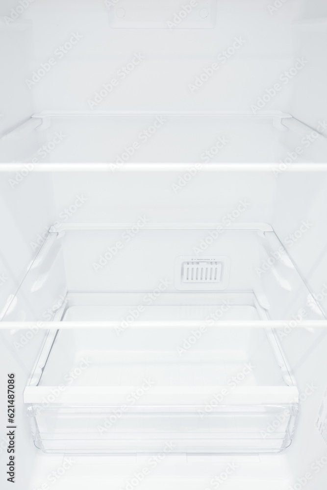 An empty refrigerator. Inside an empty, clean refrigerator, a refrigerator compartment after defrosting. shot with a wide angle lens An empty refrigerator. Inside an empty, clean refrigerator, a refrigerator compartment after defrosting. shot with a wide angle lens