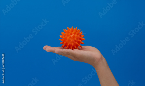 Spiky orange massage needle ball on child palm