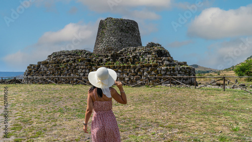 young tourist with white straw hat observes the nuraghe santu antine di torralba, a town in central sardinia
 photo