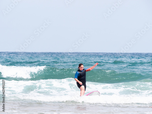 Young surfer rides surfboard in the ocean waves