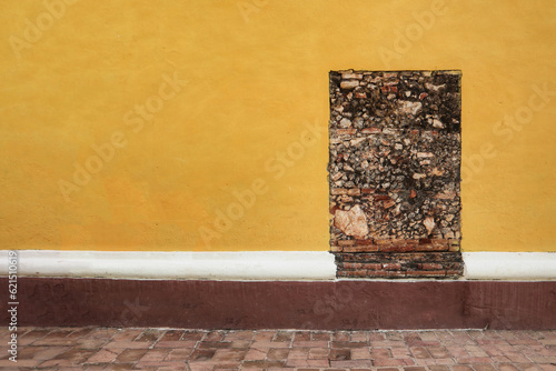 Photography a yellow wall with exposed brick patch