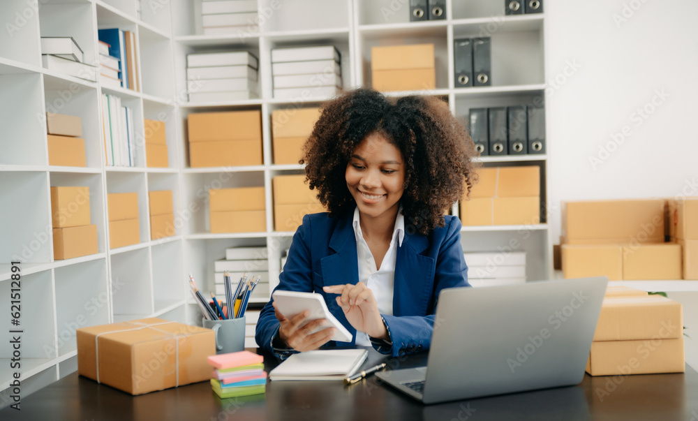 Startup small business SME, Entrepreneur owner African woman using smartphone or tablet taking receive and checking online purchase shopping order Startup small business SME, Entrepreneur owner African woman using smartphone or tablet taking receive and checking online purchase shopping order