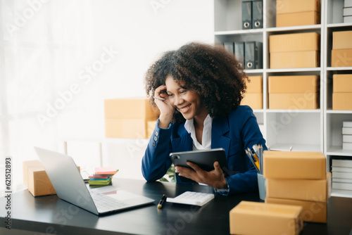 Startup small business SME, Entrepreneur owner African woman using smartphone or tablet taking receive and checking online purchase shopping order