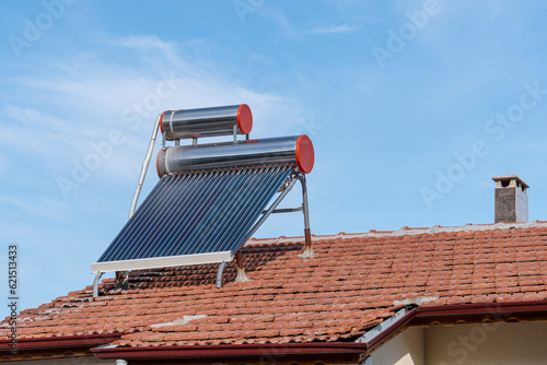 Schilderij op canvas Solar water heating panel and water collector on a house roof,blue sky backgroun