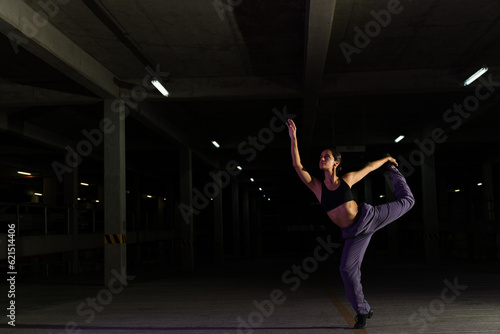 Beautiful street dancer performing at night in the parking lot