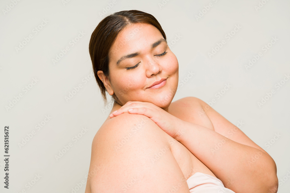 Obraz premium Overweight woman in her 30s using body care beauty products