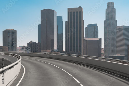 Empty urban asphalt road exterior with city buildings background. New modern highway concrete construction. Concept of way to success. Transportation logistic industry fast delivery. Los Angeles. USA.