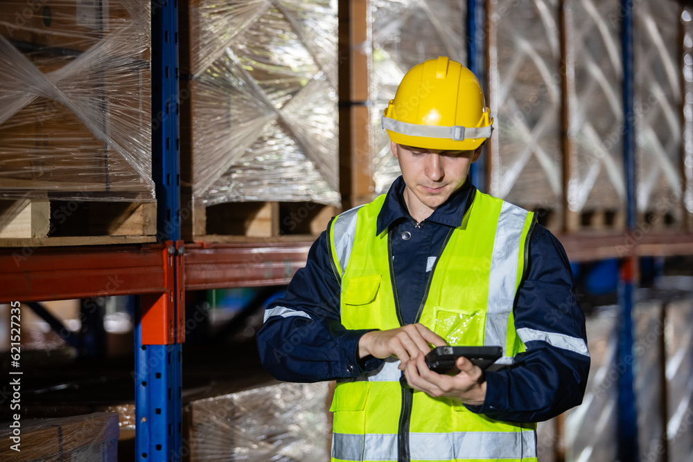 Male professional worker wearing safety uniform and hard hat using digital tablet inspect product on shelves in warehouse. Man worker check stock inspecting in storage logistic factory. Male professional worker wearing safety uniform and hard hat using digital tablet inspect product on shelves in warehouse. Man worker check stock inspecting in storage logistic factory.