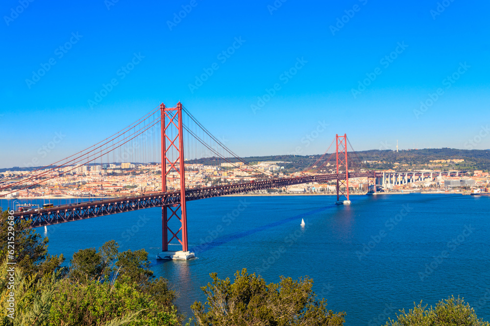 Naklejka premium The 25th April Bridge (Ponte 25 de Abril) is a suspension bridge road-rail over the Tagus river that connects the city of Lisbon to the city of Almada. View from Almada.