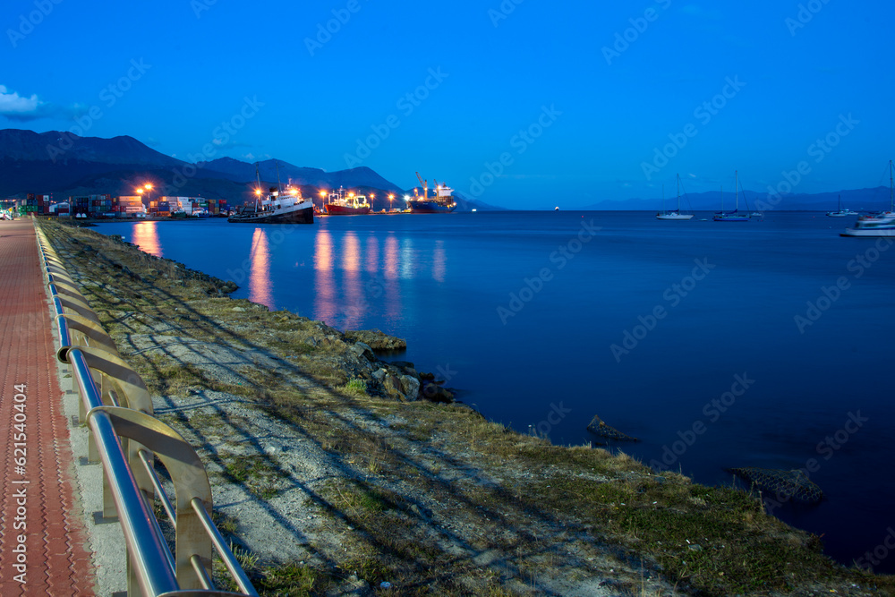 Coast of the port of Ushuaia at sunset with large ships with their lights on
