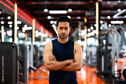 Energetic Fitness Sportsman at Gym. Asian Man Athlete Crosses Arms. Handsome Guy Smart and Confidence in Fitness Center