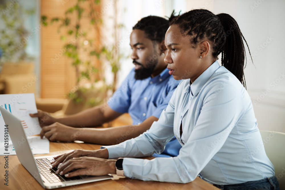 African American business couple working on a computer in the office