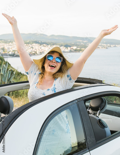 Young woman having fun in cabrio against a beach and sea - travel and summer voyage nature concept
