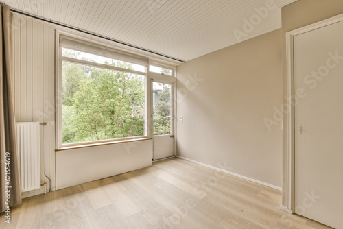 an empty room with wood flooring and large windows overlooking the trees in the distance are seen through the window