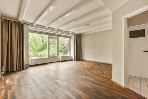 an empty living room with wood flooring and large windows looking out onto the trees in the woods behind it