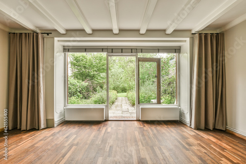 an empty room with wood flooring and large windows looking out onto the trees in the photo is taken from inside