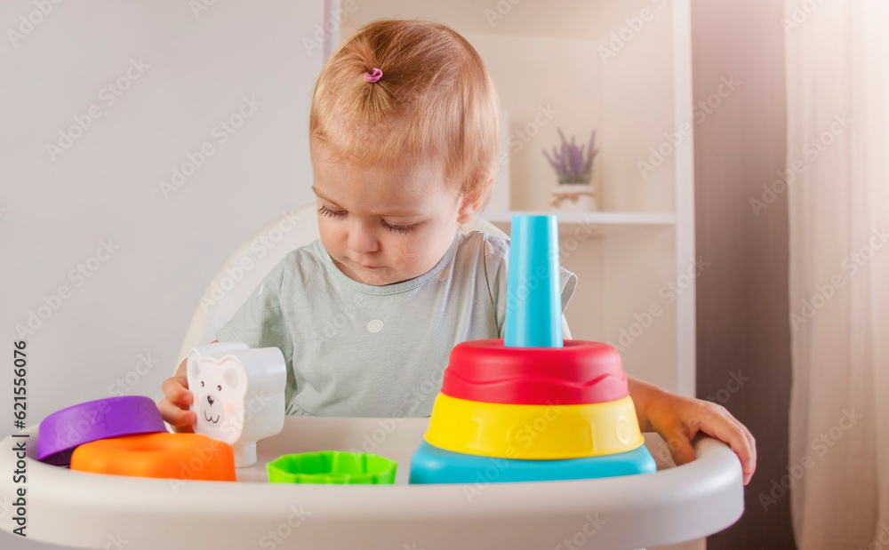 Little child plays with colorful plastic toys pyramid at home. Baby game. Games for early development Little child plays with colorful plastic toys pyramid at home. Baby game. Games for early development