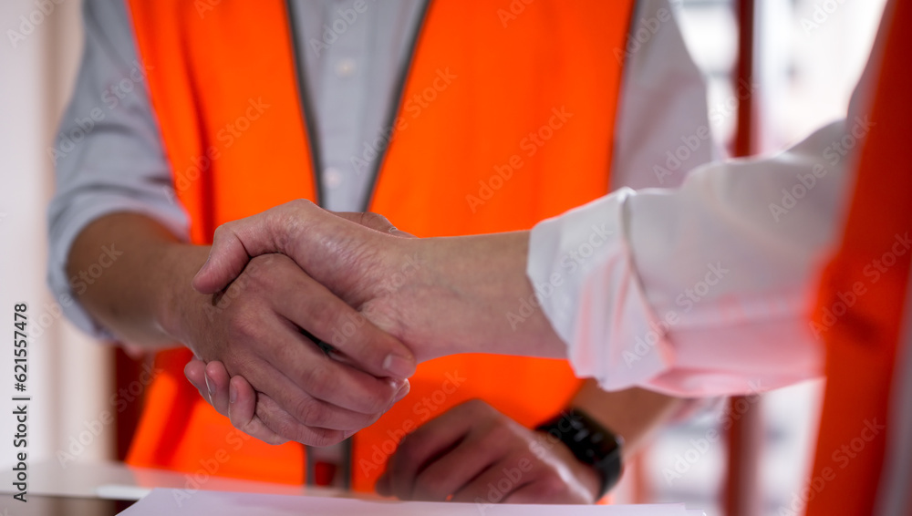 Engineers or foreman shaking hands at construction site, Construction worker in protective uniform shaking hands at construction site Engineers or foreman shaking hands at construction site, Construction worker in protective uniform shaking hands at construction site