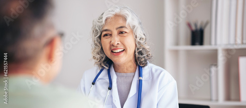 Female doctor writing prescription on clipboard while explaining medicine use and discussing about
