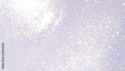 Soft slow motion white particles in liquid. Elegant silvery abstract background with glitters, bokeh and snowflakes. Christmas white sparkling glitter movement.
