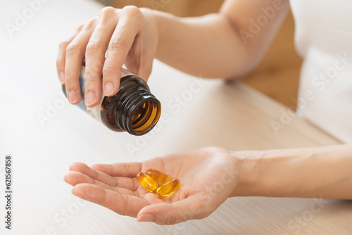 Картината върху платно Dietary supplement or sick, asian young woman, girl hold pills, drugs medical tablet on hand pouring capsules from medication bottle, take vitamin for treatment for skin, hair at home, healthcare