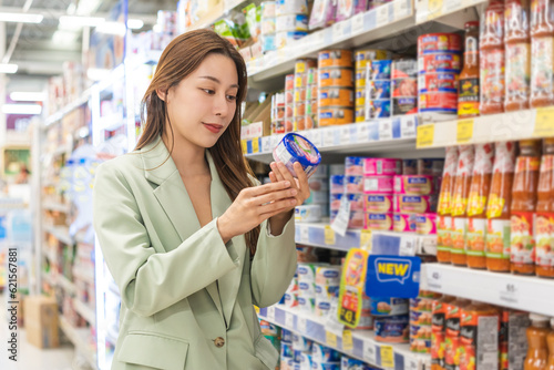 Foto Asian young woman, female in grocery, supermarket shopping food store hand holdi