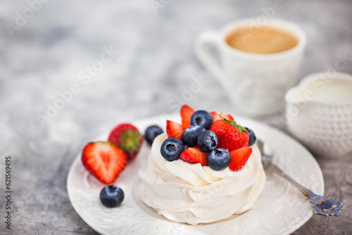 Delicious Pavlova meringue cake decorated with fresh strawberry and blueberry