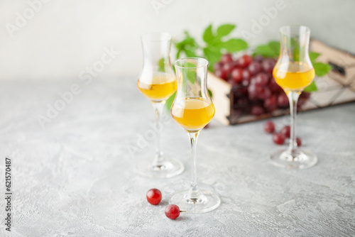Grape vodka. Strong alcoholic drink in glasses on the table. Fresh grapes