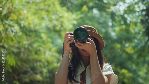 Asian woman traveller enjoy vacation moment while taking photos of nature with camera, Female hands holding camera and doing nature photography, Travel Blogger Photographing. photo