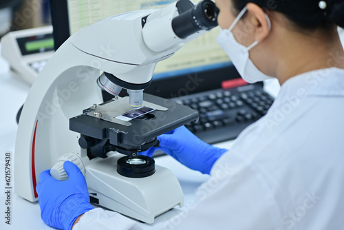 Medical Science Laboratory: Portrait of a scientist looking under a microscope without analyzing a test sample. Ambitious young biotechnologist working with advanced equipment.