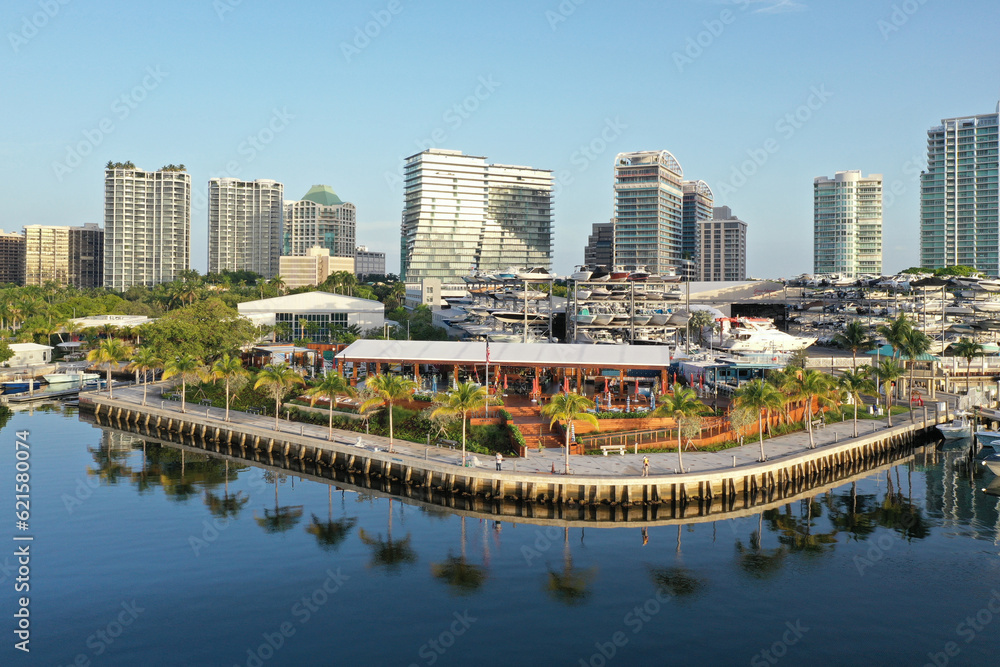 Obraz premium Aerial view of waterfront bars, restaurants and marina in Coconut Grove, Miami, Florida with skyline in background on calm clear sunny summer morning.