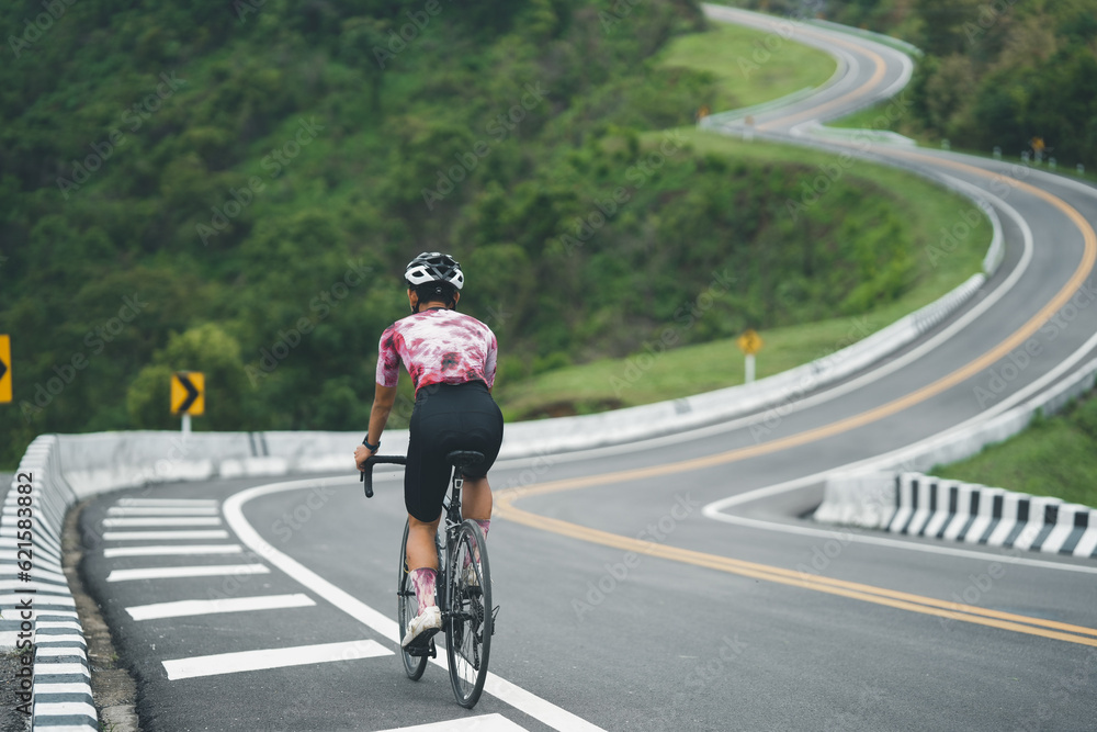 Obraz premium Cyclist pedaling on a racing bike outdoors.The image of cyclist in motion on the background in the evening.