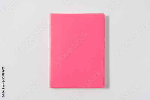 Pink notebook on white desk. Business minimal concept for women. Flat lay, top view, copy space