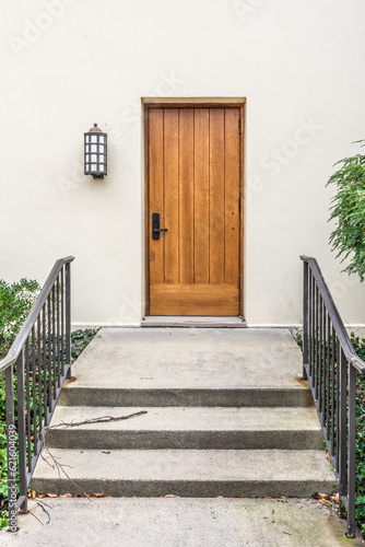 The entrance to the house with the wooden door and stairs