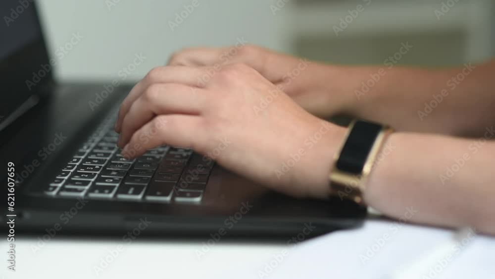 Female hands of a businesswoman professional user-an employee typing on a laptop keyboard, sitting at a table, a student working on a laptop, a programmer typing quickly on the keyboard. side view Female hands of a businesswoman professional user-an employee typing on a laptop keyboard, sitting at a table, a student working on a laptop, a programmer typing quickly on the keyboard. side view