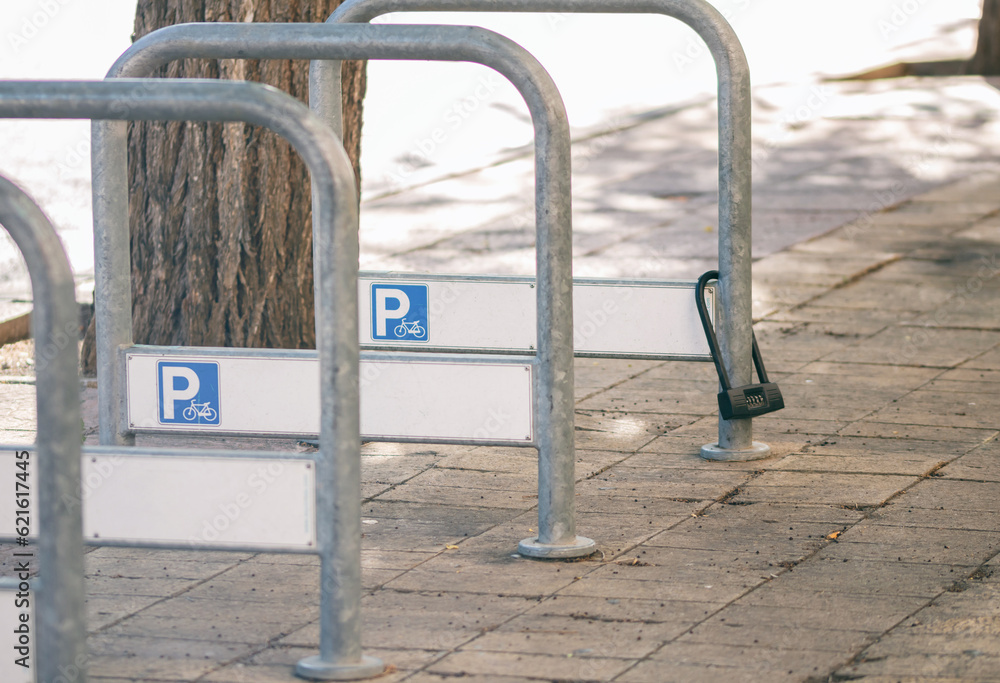 Park lot.Closed padlock on a parking for bicycles in the city. Park lot.Closed padlock on a parking for bicycles in the city.
