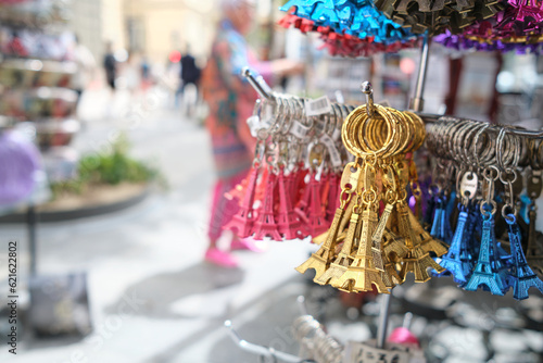 Parisian souvenirs key chains in the form of the Eiffel Tower, bundles of golden, blue and red pieces hang in a street store