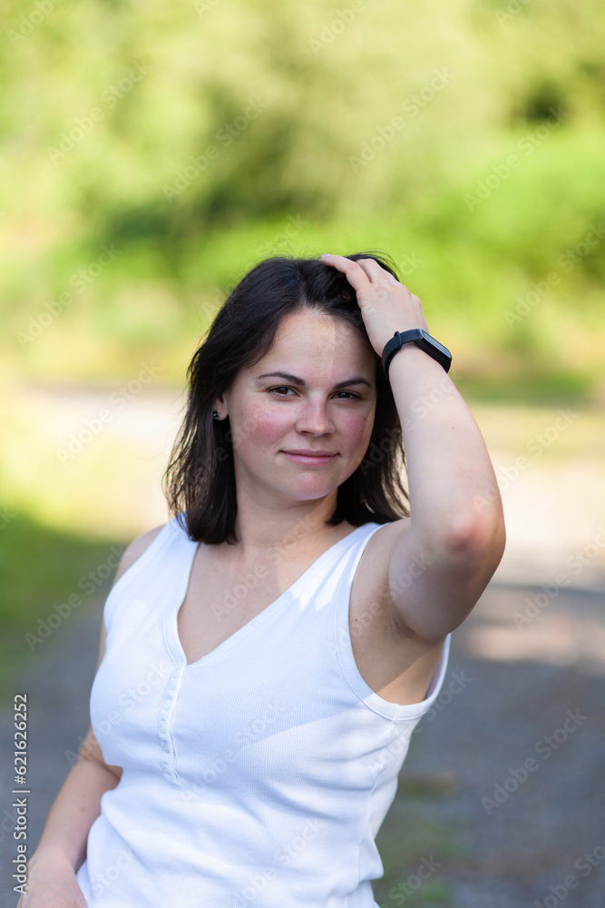 portrait of a beautiful girl in a white T-shirt in the park
