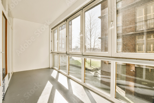 an empty room with large windows and no one person in the photo is looking out to the other area outside